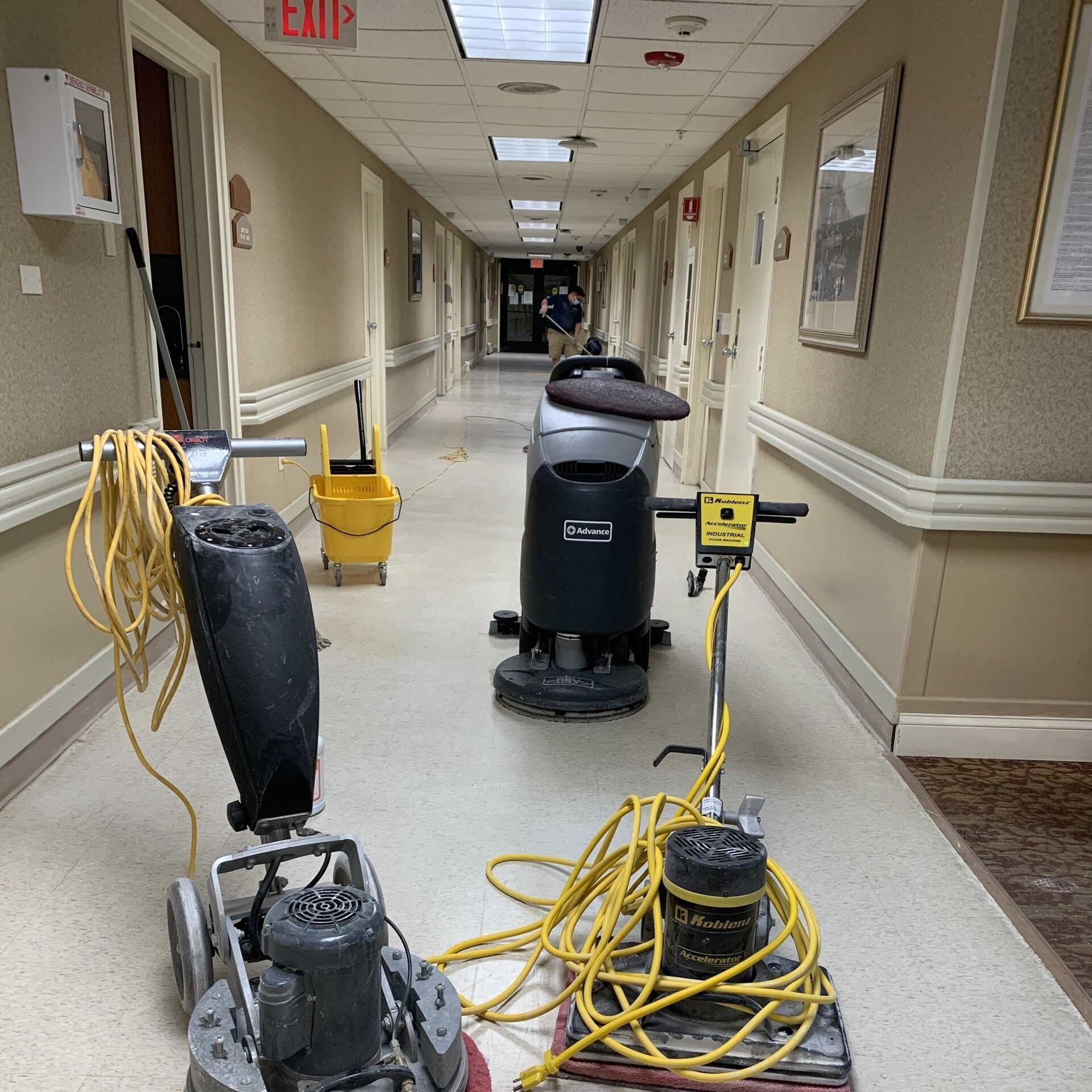 Commercial floor cleaning equipment in a long hallway.